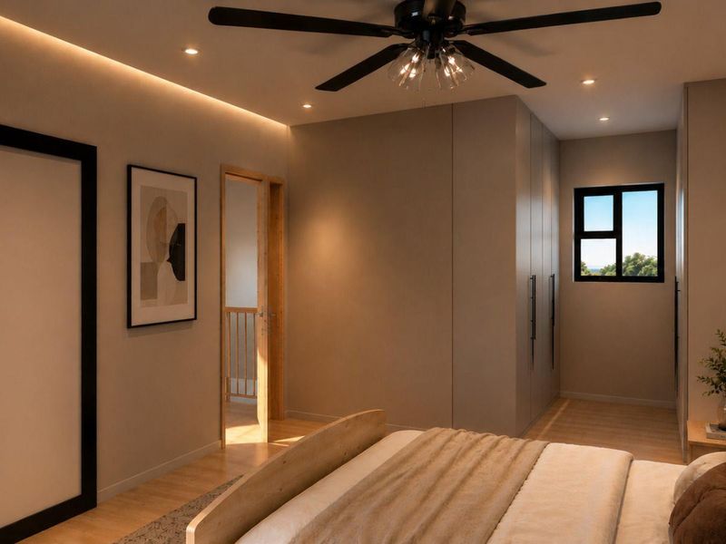 Modern bedroom featuring built-in cupboards, timber flooring, recessed and cove lighting, and a ceiling fan.