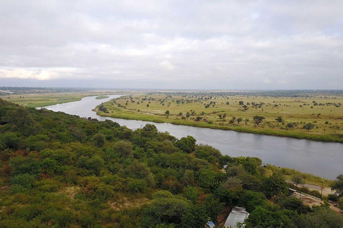 A scenic aerial view overlooking a winding river flowing through a vast, natural savanna landscape.