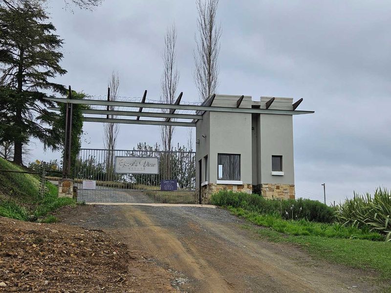 The entrance to Guest's View Estate featuring a secure gated access point, a modern guard house with stone accents, and established landscaping.