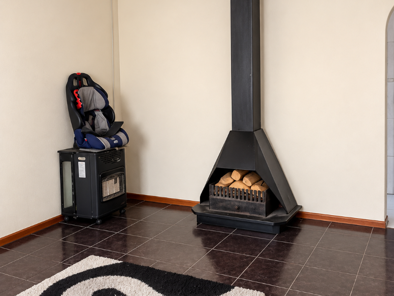 Living area featuring dark tiled flooring and a prominent black freestanding fireplace with a chimney flue.