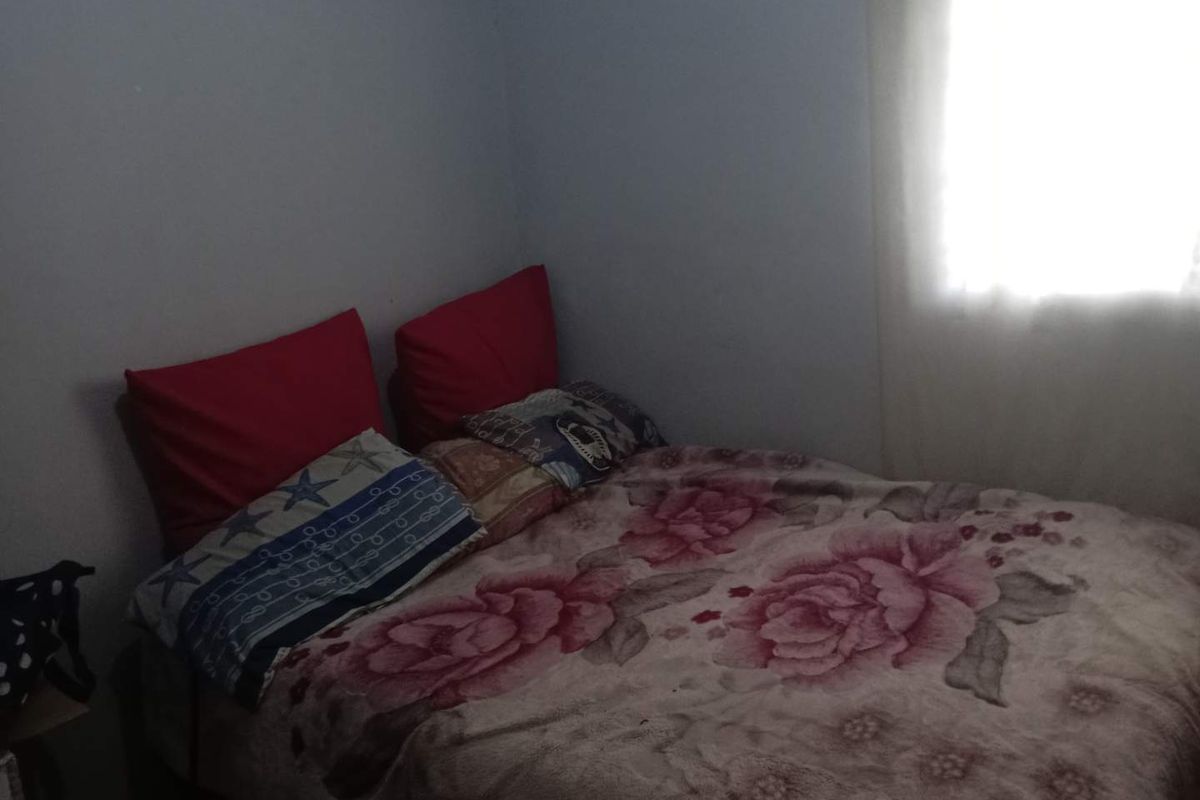 A bedroom featuring a window with natural light, providing a functional space for rest.