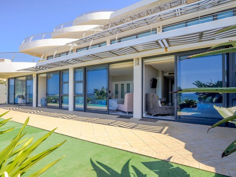 Spacious ground floor patio featuring tiled flooring, a protective metal pergola, and large sliding glass doors providing seamless indoor-outdoor flow.