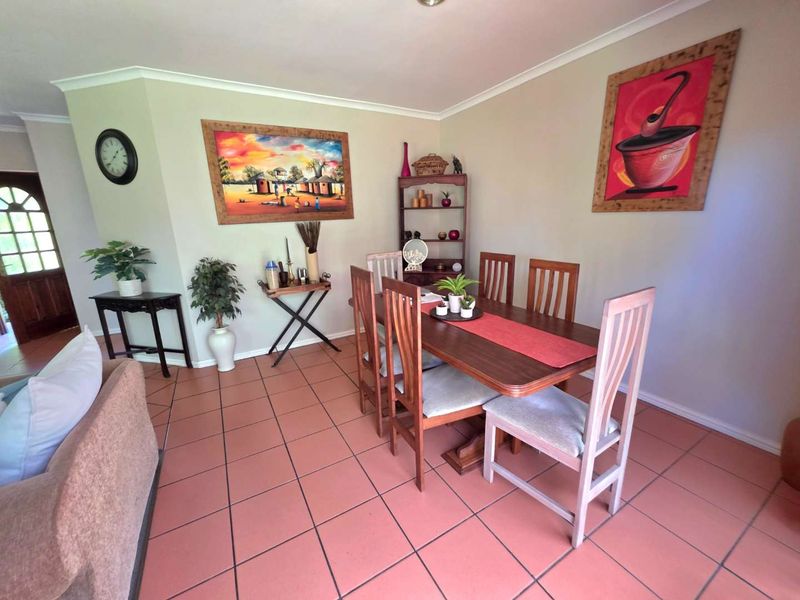 A dining area featuring terracotta floor tiles and coved ceiling cornices, providing a functional space for family meals.