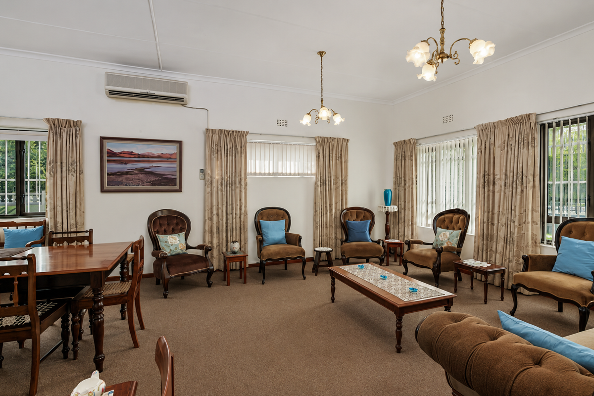 Spacious living room featuring neutral walls, carpeted flooring, multiple windows with curtains, and a wall-mounted air conditioning unit.