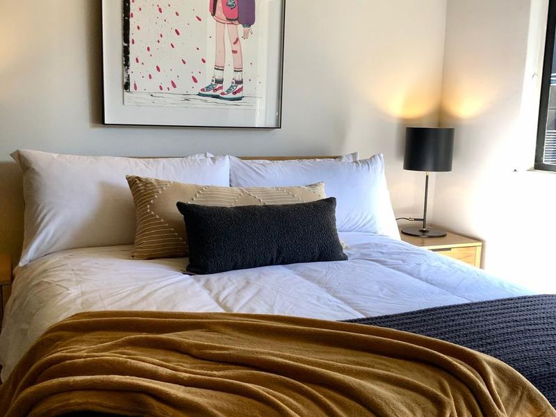A well-lit bedroom featuring neutral walls and a window, providing a comfortable and inviting sleeping space.