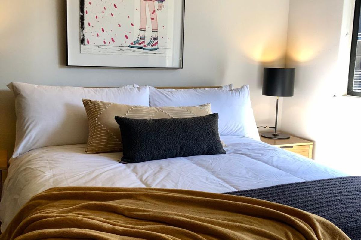 A well-lit bedroom featuring neutral walls and a window, providing a comfortable and inviting sleeping space.