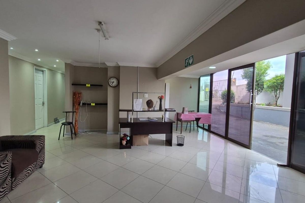 Spacious open-plan living area featuring large sliding glass doors, tiled flooring, and recessed lighting, offering direct access to the exterior.
