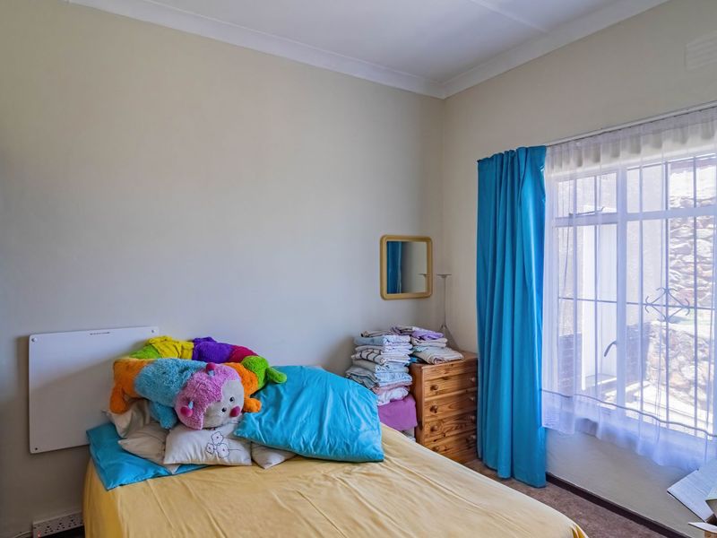 A bedroom featuring a built-in wardrobe, security bars on the window, and cove cornice detailing.