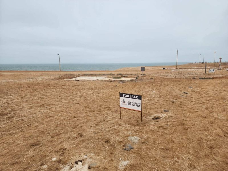 Vacant residential land featuring a concrete slab foundation and direct ocean views, situated in a coastal development.