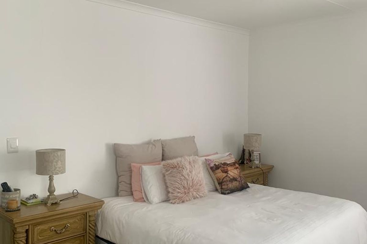 A well-maintained bedroom featuring a modern ceiling fan and neutral wall finishes, providing a clean and comfortable living space.