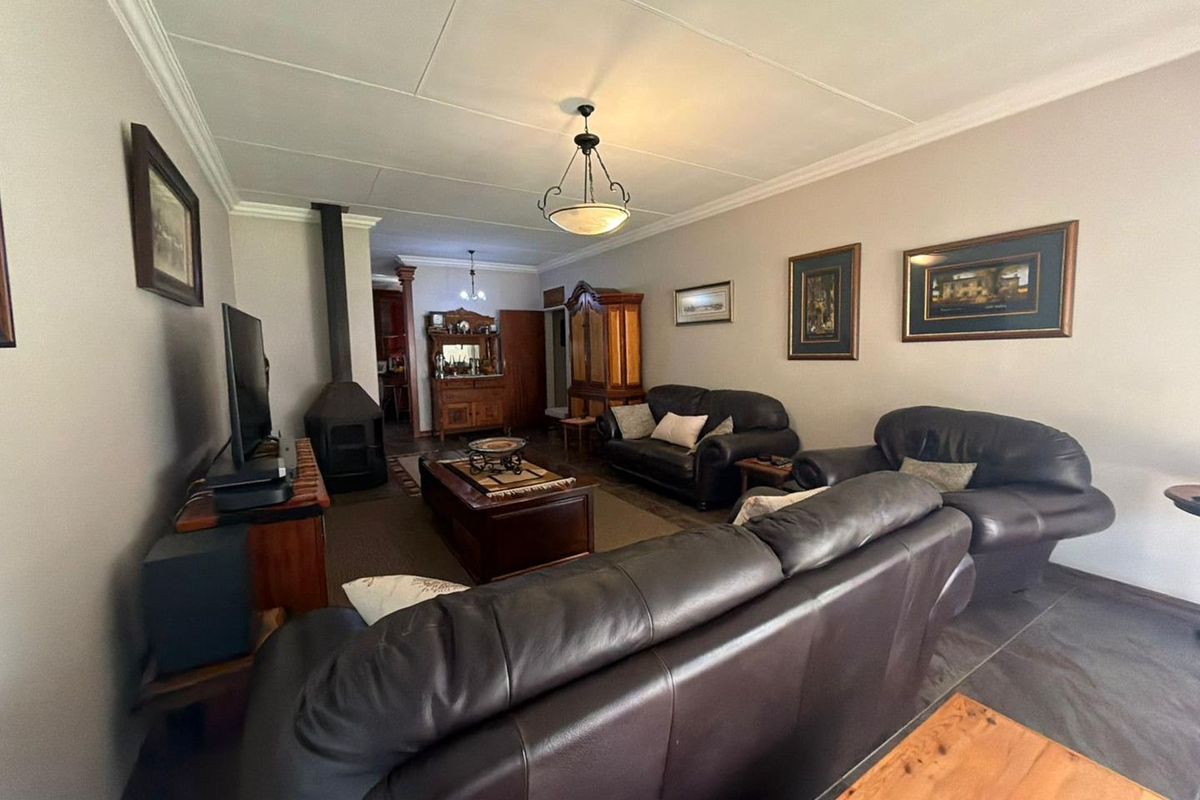 A comfortable living room featuring a freestanding fireplace, decorative ceiling cornices, and neutral wall finishes.