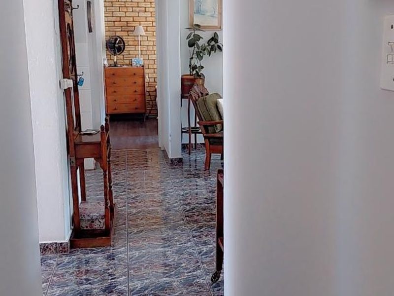 A functional hallway featuring patterned tiled flooring and access to adjacent living spaces.