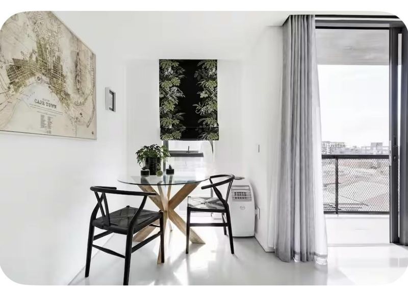 Bright living area featuring neutral finishes, clean lines, and direct access to a private balcony through a large sliding glass door.