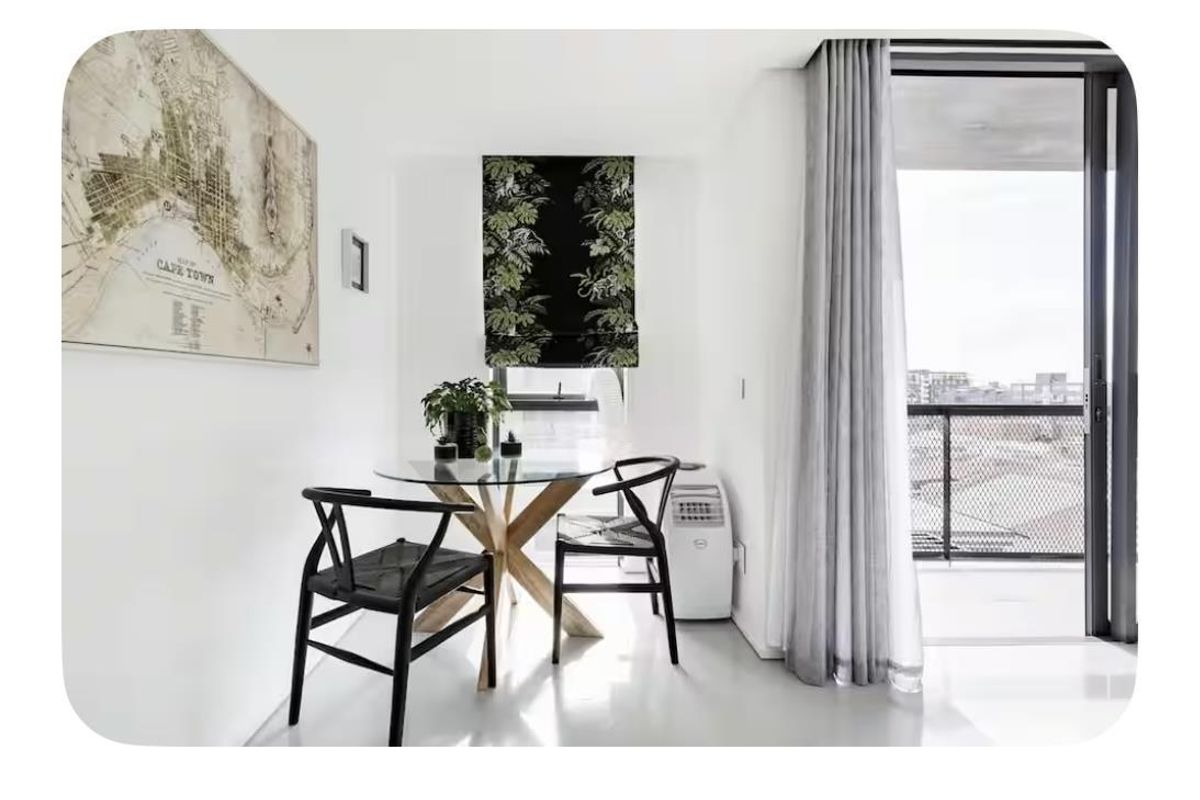Bright living area featuring neutral finishes, clean lines, and direct access to a private balcony through a large sliding glass door.