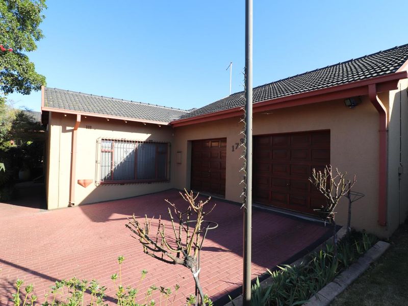Front exterior view of the property featuring a paved driveway and a double garage with secure access.
