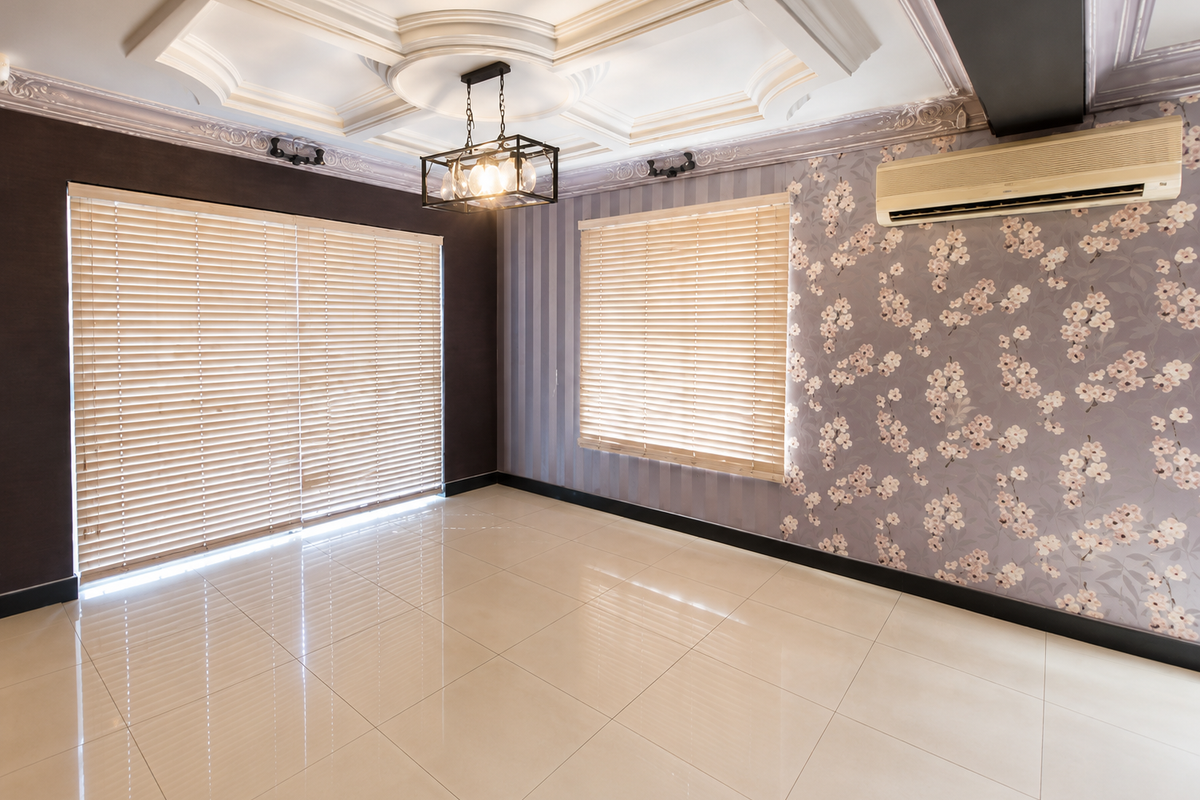 Spacious living area featuring elegant coffered ceilings, decorative floral wallpaper, polished tile flooring, and a wall-mounted air conditioning unit.