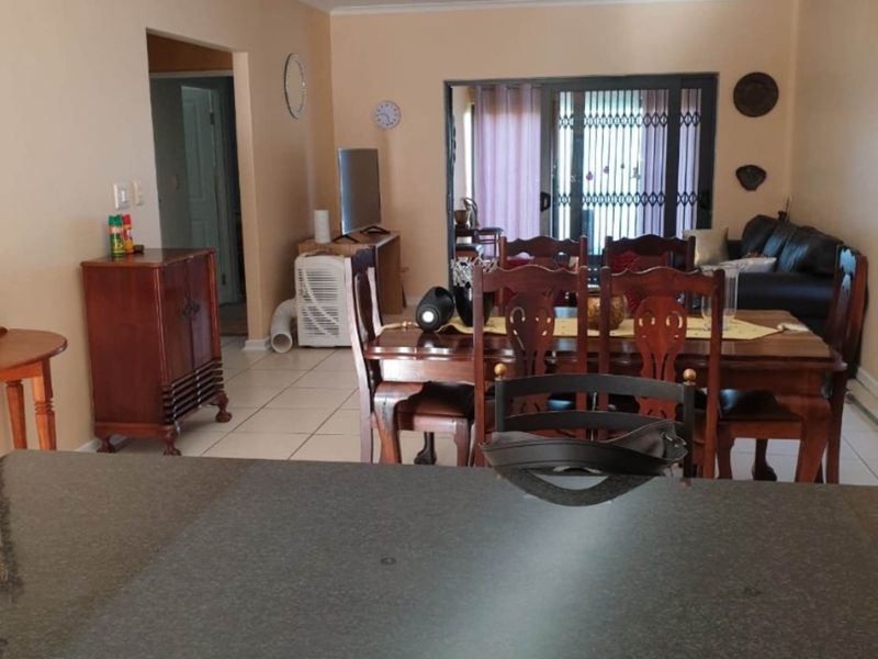 Open plan living and dining area featuring tiled flooring, recessed lighting, and a sliding door leading to the exterior.