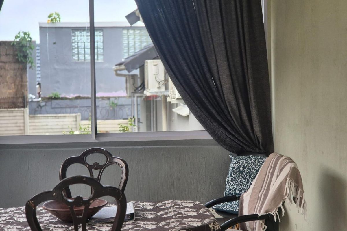A view from a living area looking out through a sliding window towards neighboring properties.