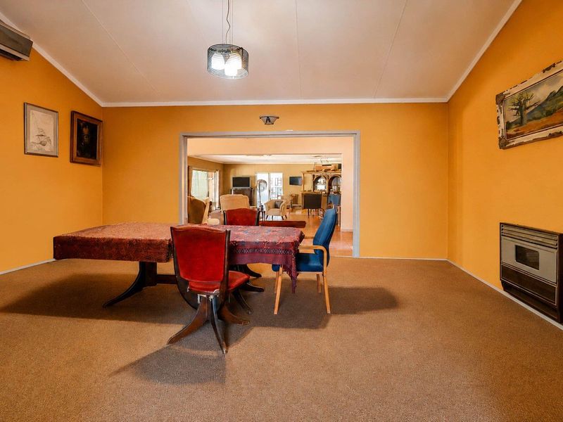 Dining room featuring a built-in fireplace, air conditioning unit, and direct access to the adjacent living area.