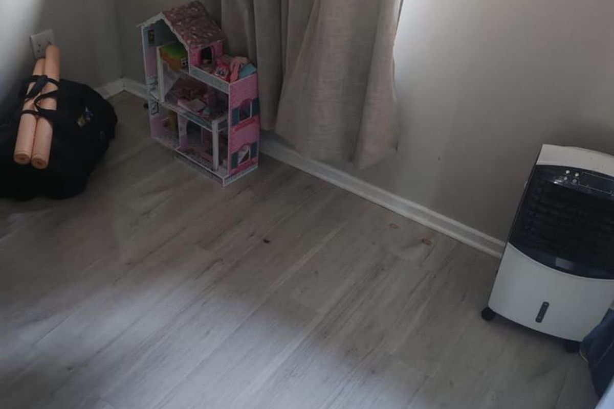 A bedroom featuring light-toned laminate flooring and neutral wall finishes, providing a clean and versatile space.
