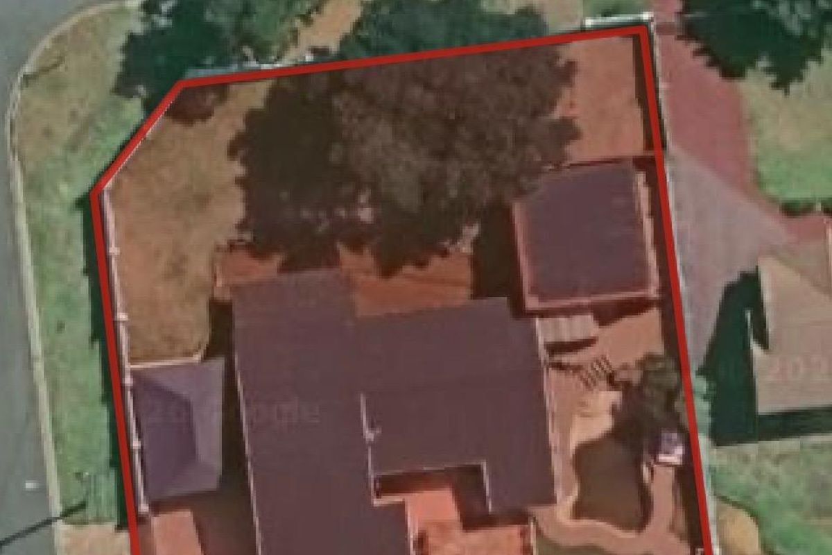 Aerial view of the property showing the house footprint, swimming pool, and surrounding garden area within the boundary.