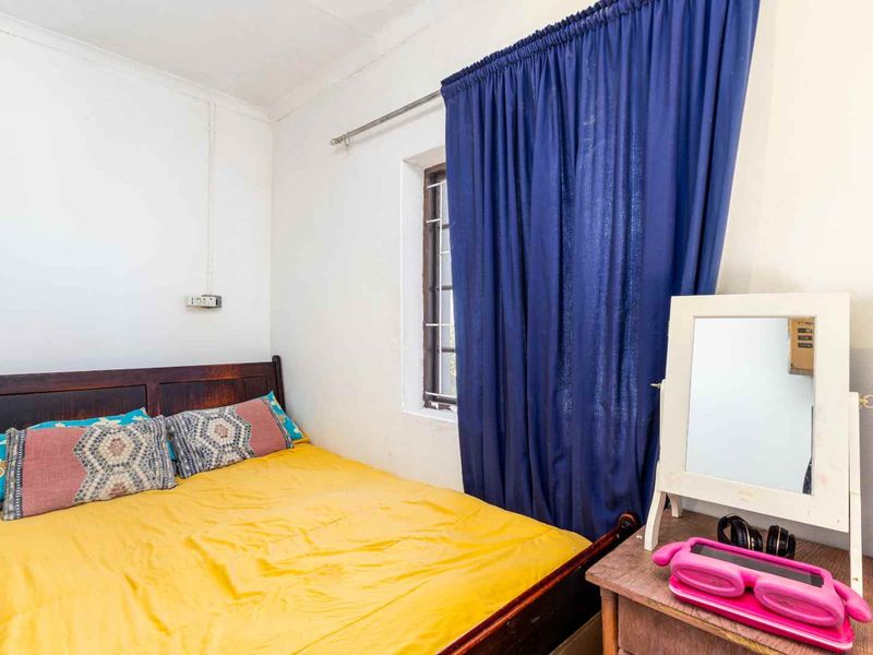 A functional bedroom featuring a window with a curtain rail and standard wall finishes.