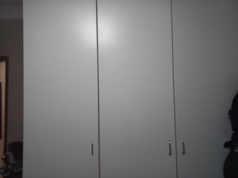 A view of built-in bedroom cupboards with a neutral finish.
