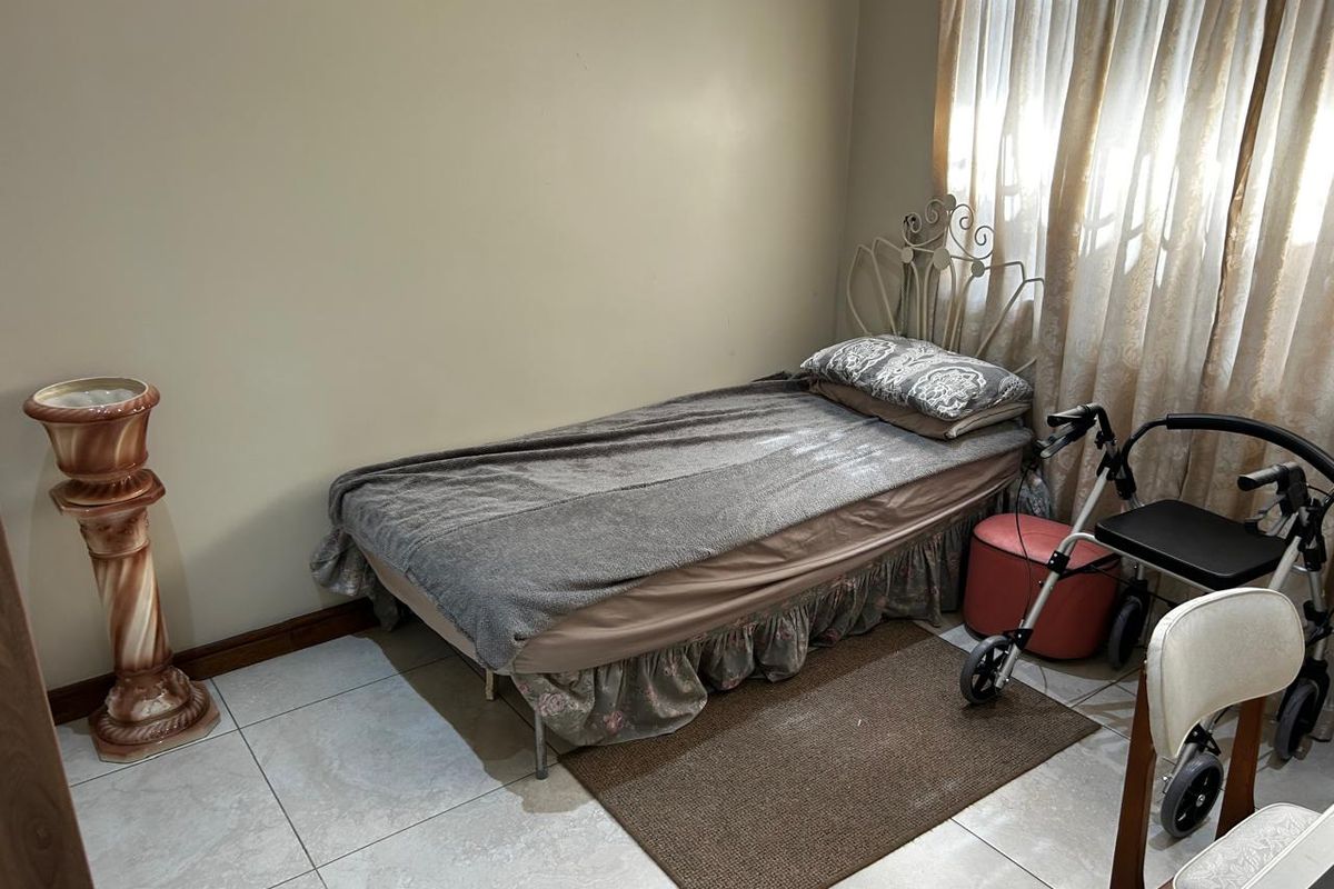 A functional bedroom featuring tiled flooring and neutral wall finishes, suitable for comfortable retirement living.