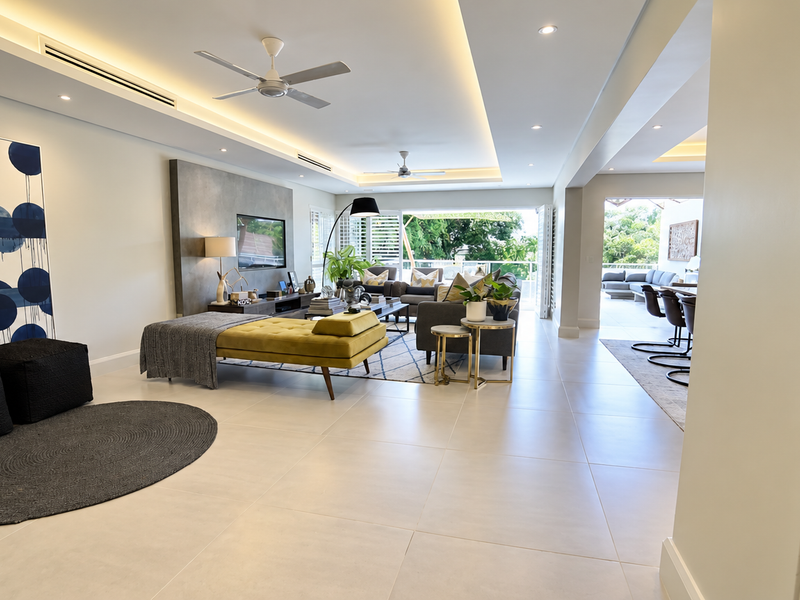 Spacious open-plan living area featuring modern tiled floors, recessed lighting, ducted air conditioning, and seamless indoor-outdoor flow through large bi-fold doors.