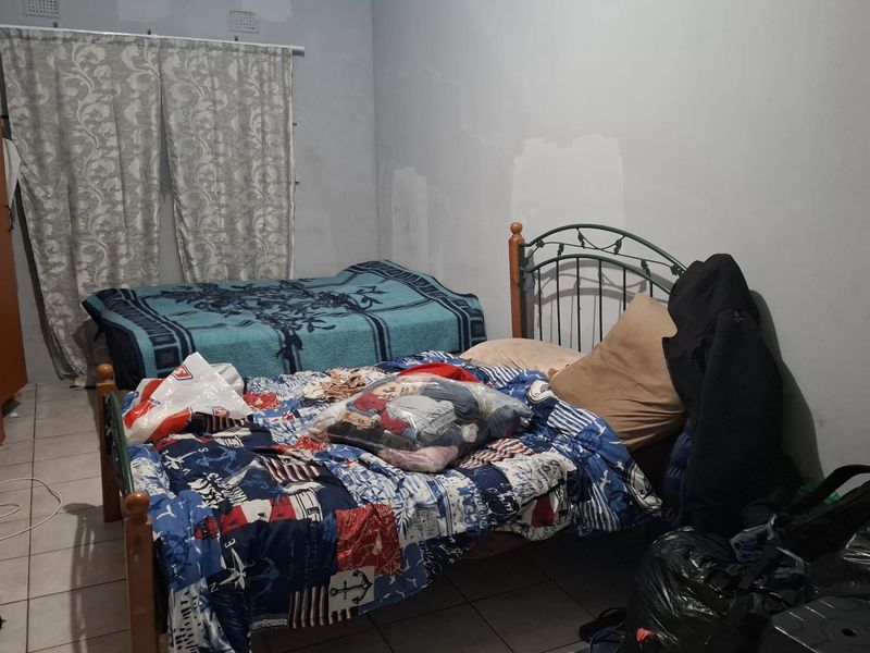 A bedroom featuring tiled flooring and unfinished wall surfaces, presenting an opportunity for cosmetic updates and interior finishing.
