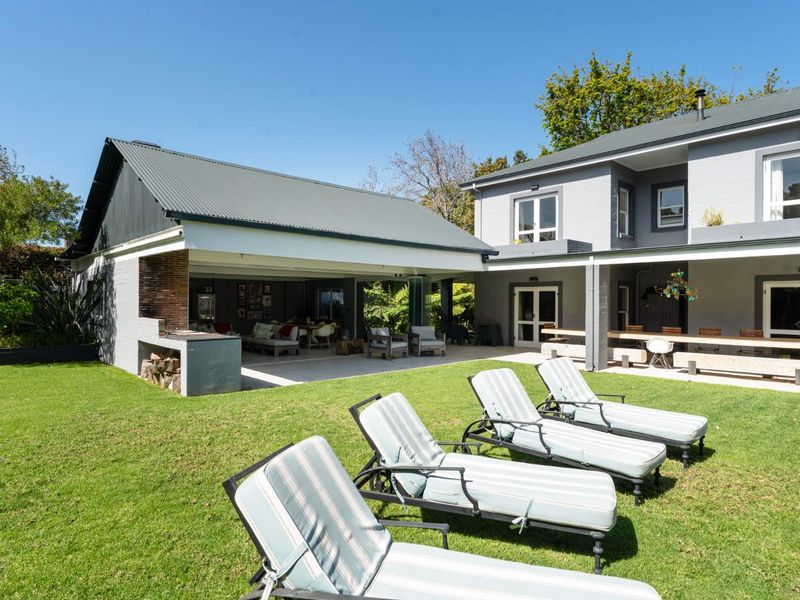 Spacious rear garden featuring a covered patio with a built-in braai, ideal for outdoor entertaining and relaxation.