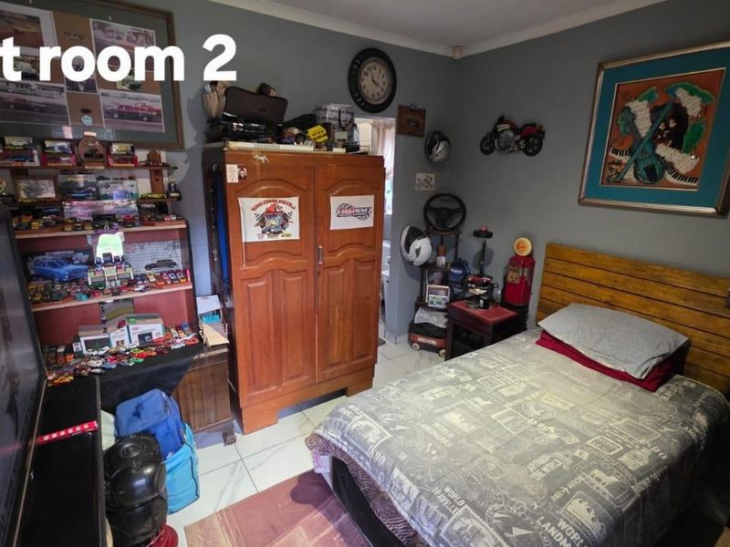 A bedroom featuring tiled flooring and coved ceiling details, currently utilized as a personal hobby space.