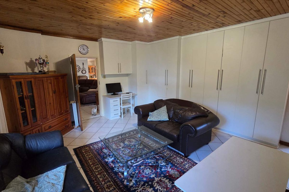 A bedroom featuring extensive built-in cabinetry, tiled flooring, and a timber-clad ceiling, offering ample storage space.