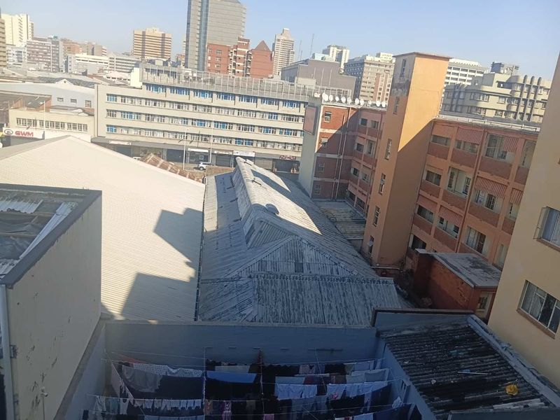 An elevated urban view overlooking surrounding apartment buildings and industrial rooftops in a dense city environment.