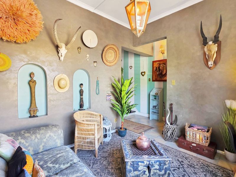 A cozy living room featuring unique arched wall niches, textured plaster walls, and a decorative pendant light fixture.