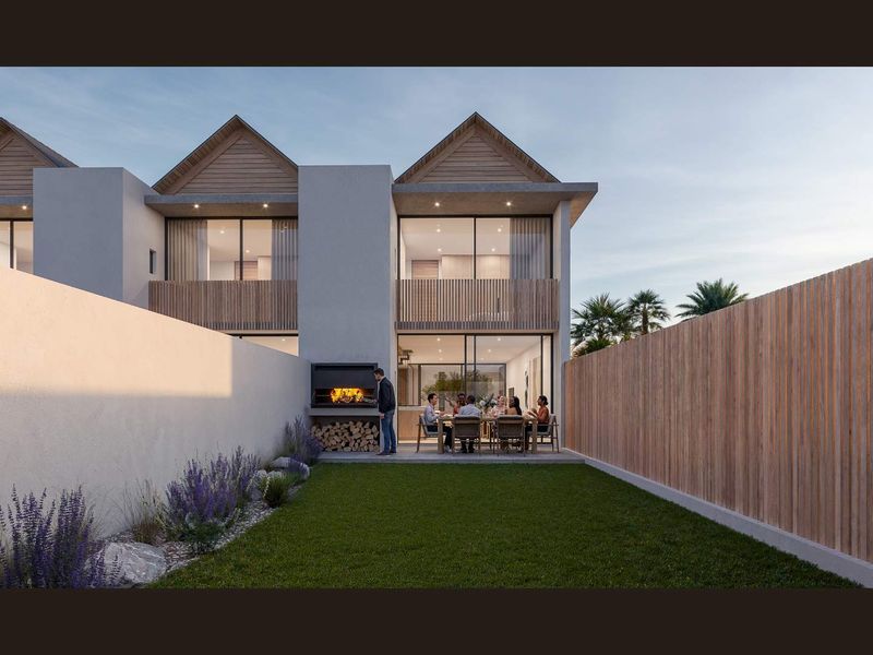 A modern townhouse rear garden featuring a paved patio, built-in braai, and timber slat fencing, providing a private outdoor entertainment space.