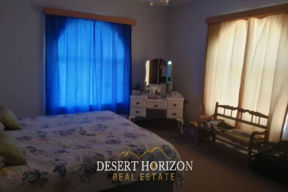 A bedroom featuring carpeted flooring and window treatments, providing a functional space for rest.