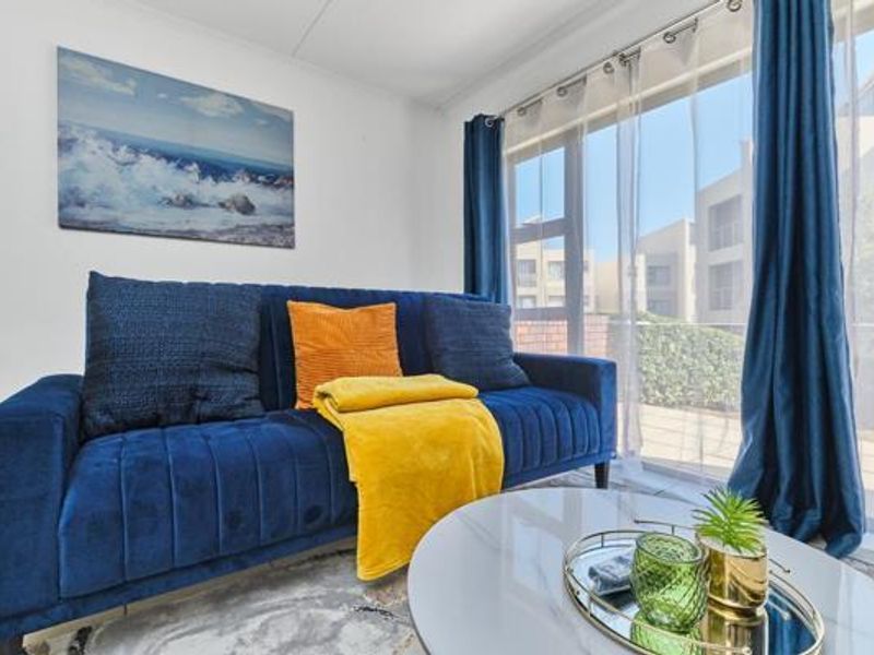 A bright living room featuring a large sliding glass door that provides ample natural light and access to the exterior.
