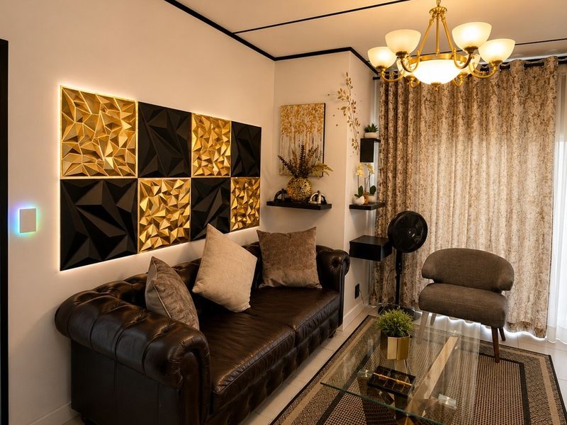 A well-appointed living room featuring decorative geometric wall panels with integrated lighting, a classic chandelier, and neutral tiled flooring.