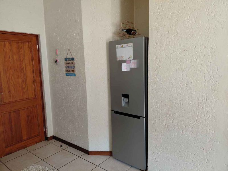 A functional kitchen area featuring tiled flooring and a dedicated recessed alcove for a refrigerator.