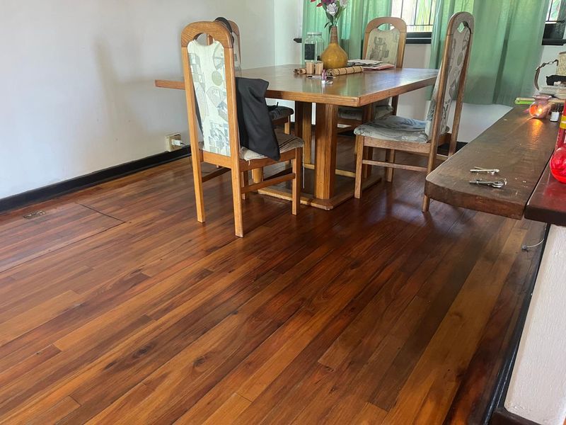A dining area featuring polished hardwood flooring and traditional skirting boards, providing a warm and classic foundation for the space.