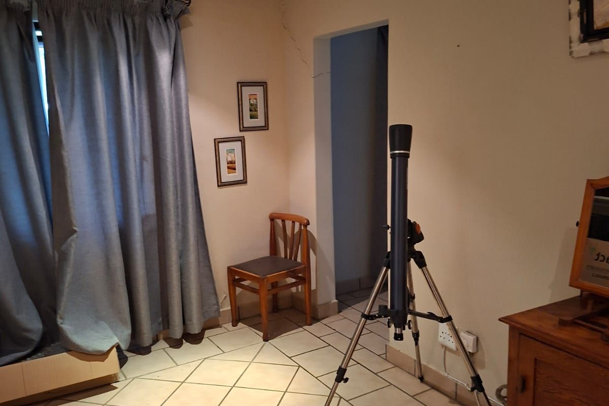 Bedroom featuring tiled flooring and a ceiling fan, showing a visible structural crack on the wall near the doorway.