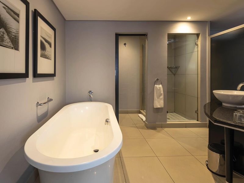 Modern bathroom featuring a freestanding bathtub, separate glass-enclosed shower, and a sleek vanity with a vessel sink and granite countertop.