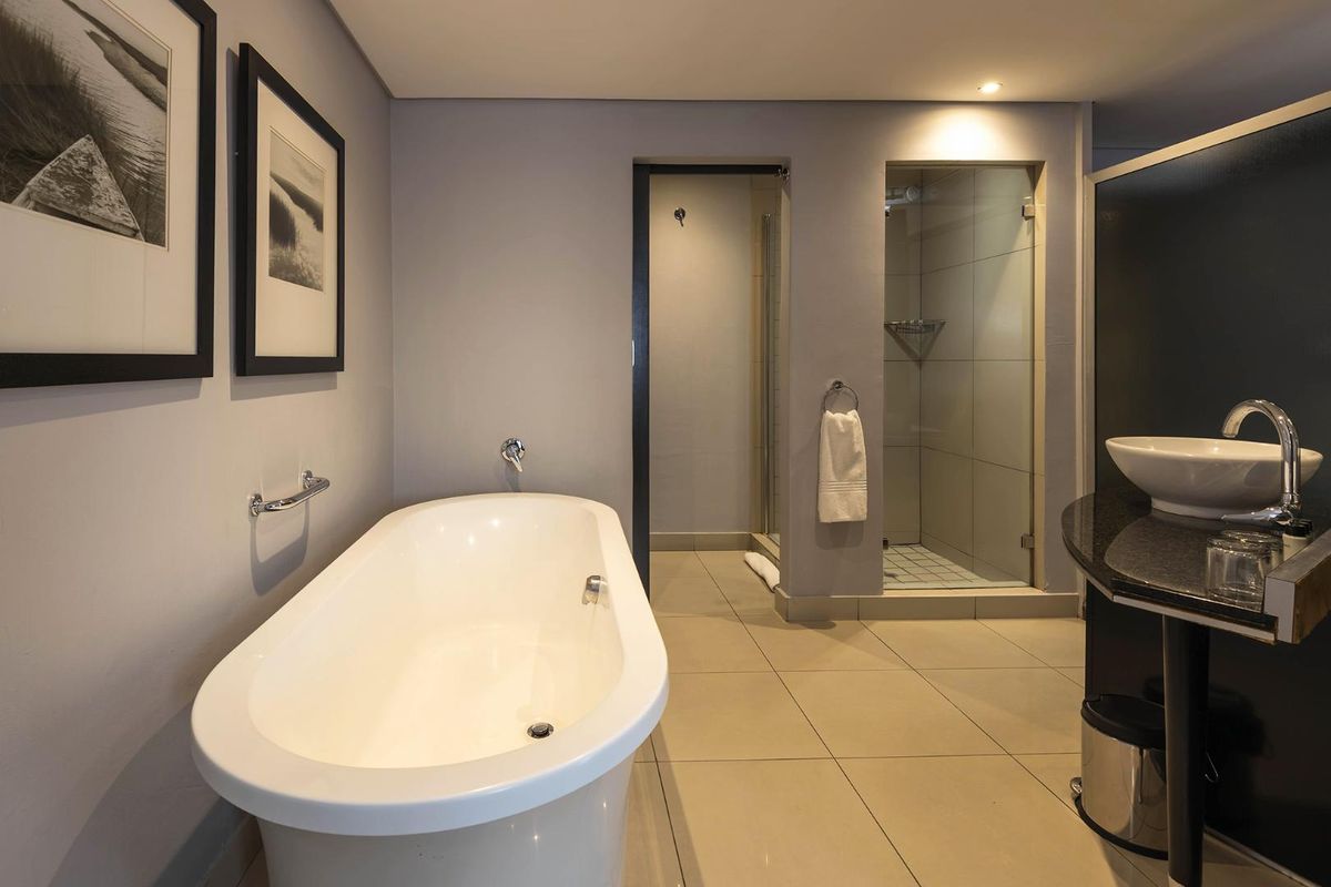 Modern bathroom featuring a freestanding bathtub, separate glass-enclosed shower, and a sleek vanity with a vessel sink and granite countertop.