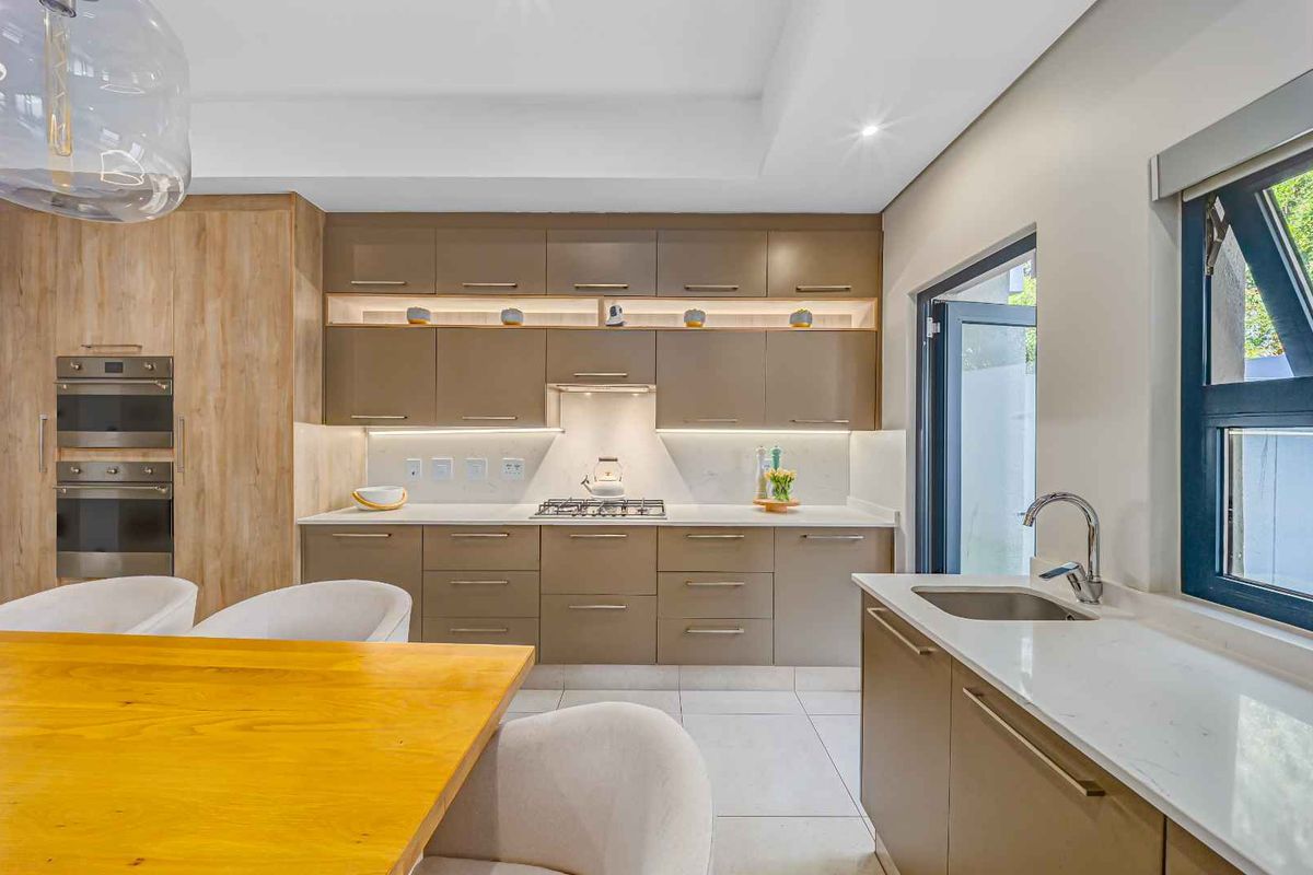 Modern kitchen featuring sleek cabinetry, integrated appliances, quartz countertops, and high-quality finishes with ample under-cabinet lighting.