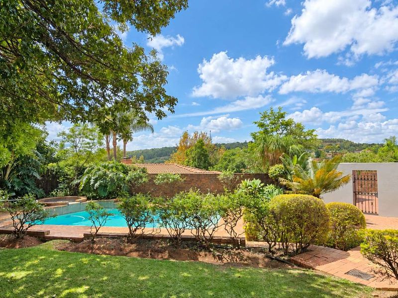 A well-maintained outdoor pool area featuring a swimming pool, brick paving, and an external staircase leading to the upper level of the house.