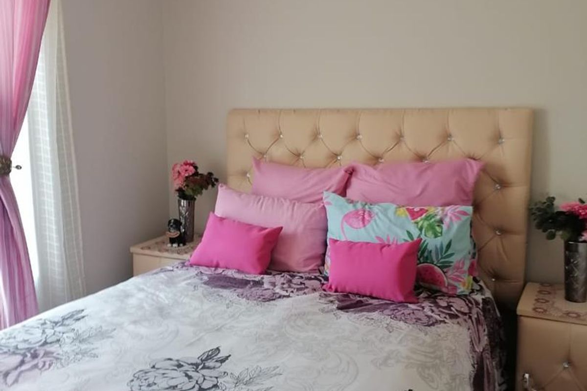A cozy bedroom featuring tiled flooring and neutral wall tones, providing a comfortable and functional sleeping space.