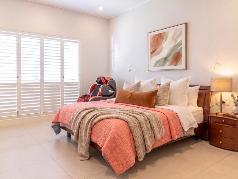 A well-maintained bedroom featuring neutral tiled flooring, recessed lighting, and plantation shutters that allow for natural light control.