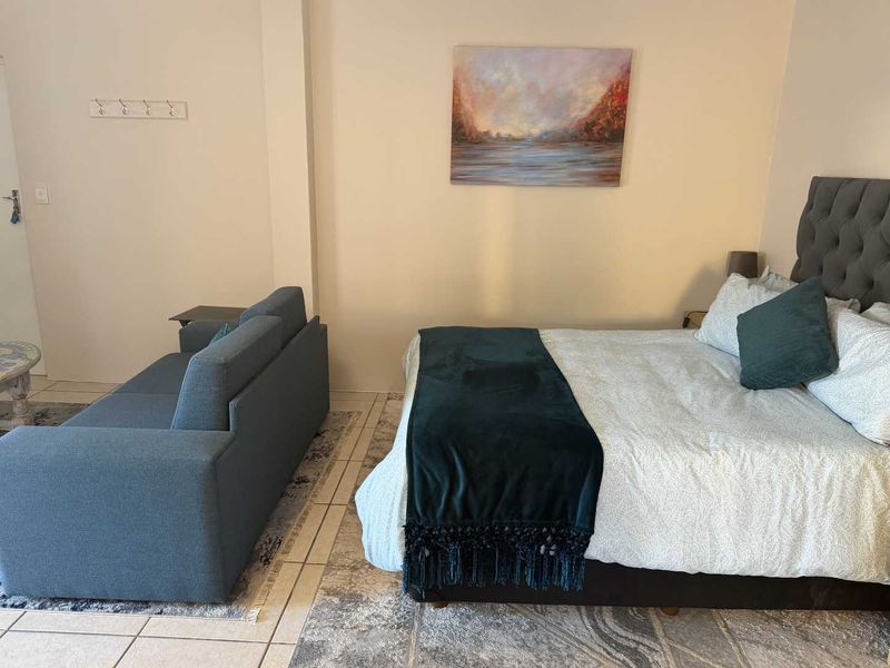 A bedroom featuring tiled flooring and wall-mounted coat hooks, providing a functional space with neutral wall finishes.