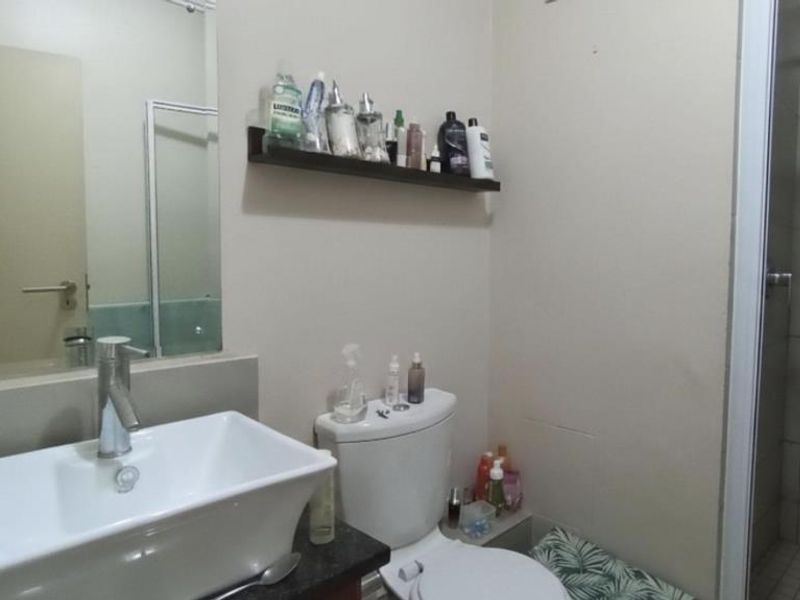 A functional bathroom featuring a modern vessel sink on a granite vanity, a toilet, and a separate shower enclosure with tiled walls.
